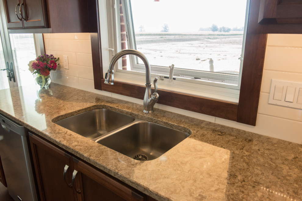 Large transitional l-shaped medium tone wood floor open concept kitchen photo with an undermount sink, flat-panel cabinets, medium tone wood cabinets, quartz countertops, white backsplash, ceramic backsplash, stainless steel appliances, an island and multicolored countertops