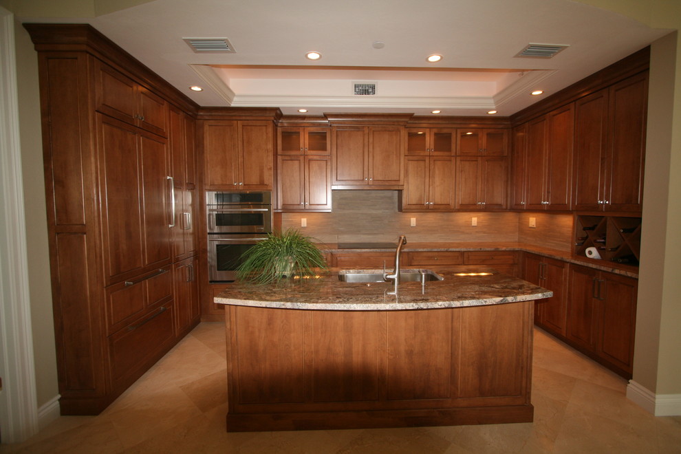 This is an example of a mid-sized transitional l-shaped eat-in kitchen in Miami with an undermount sink, shaker cabinets, medium wood cabinets, marble benchtops, beige splashback, stone slab splashback, stainless steel appliances, medium hardwood floors and a peninsula.