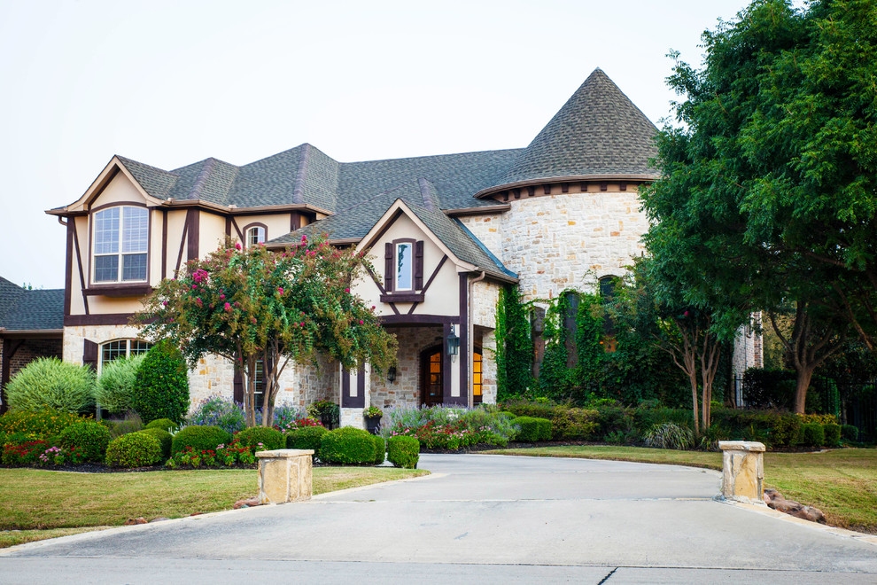 Inspiration for a large traditional two-storey beige house exterior in Dallas with mixed siding and a shingle roof.