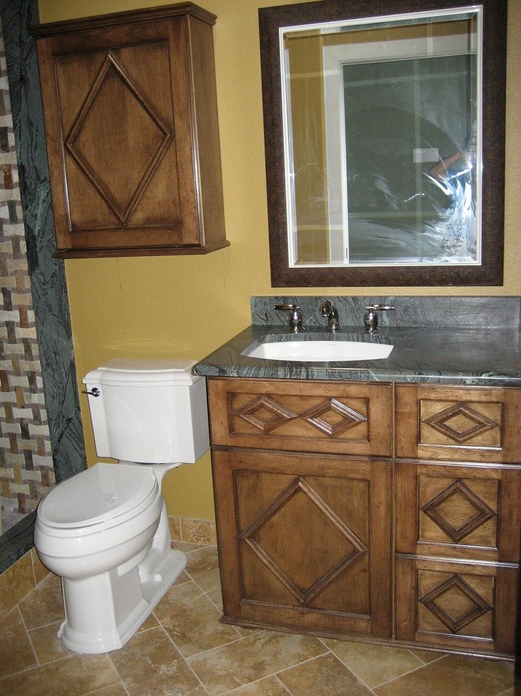 Design ideas for a bathroom in Las Vegas with furniture-like cabinets, medium wood cabinets, an open shower, a two-piece toilet, brown tile, porcelain tile, yellow walls, porcelain floors, an undermount sink and granite benchtops.