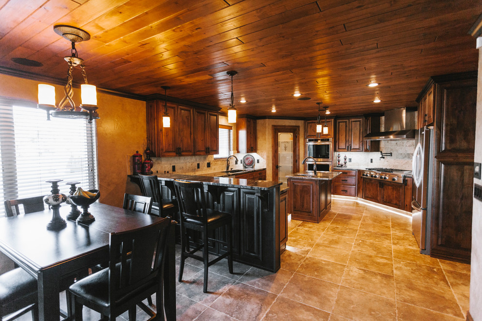 Transitional kitchen photo with a drop-in sink, dark wood cabinets, quartz countertops, beige backsplash, custom tile backsplash, stainless steel appliances, beige walls and an island