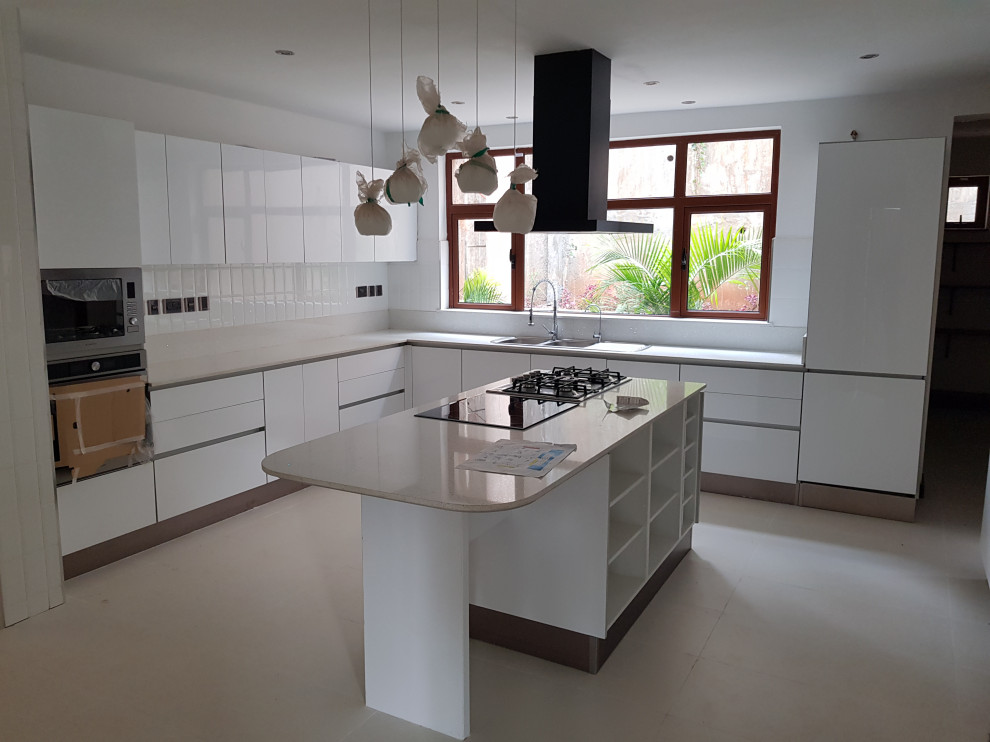 Photo of a contemporary u-shaped eat-in kitchen in Other with a double-bowl sink, flat-panel cabinets, white cabinets, granite benchtops, white splashback, granite splashback, ceramic floors, with island, white floor and white benchtop.