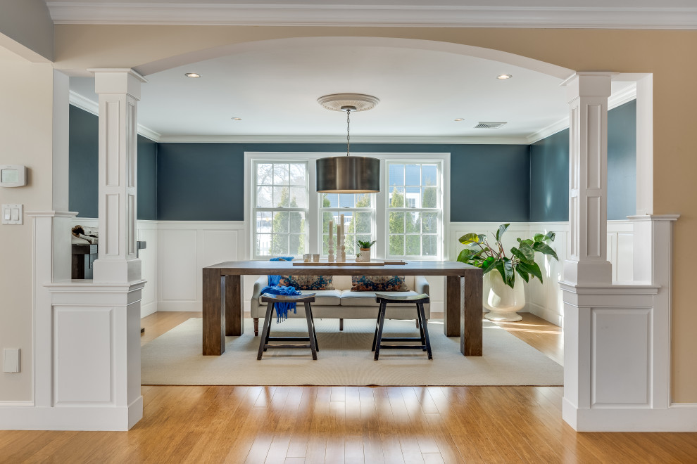 Photo of a transitional separate dining room in Boston with blue walls, medium hardwood floors, brown floor and decorative wall panelling.