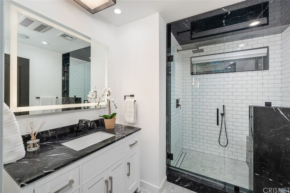 Mid-sized modern master bathroom in Los Angeles with shaker cabinets, white cabinets, an alcove shower, a one-piece toilet, white walls, marble floors, an integrated sink, marble benchtops, white floor, a hinged shower door, black benchtops, a shower seat, a single vanity and a freestanding vanity.