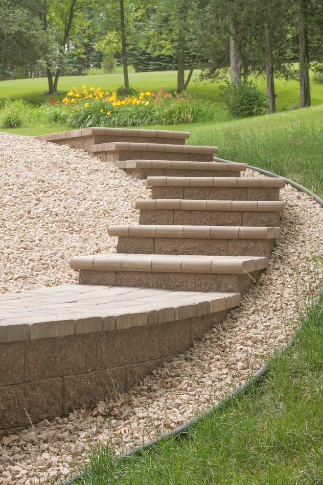 Inspiration for a large traditional sloped partial sun garden in Minneapolis with gravel.