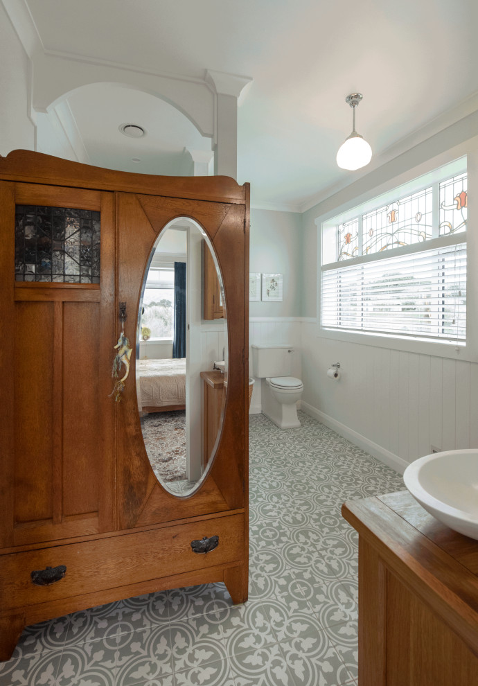 Inspiration for a mid-sized arts and crafts master wet room bathroom in Hamilton with shaker cabinets, medium wood cabinets, a two-piece toilet, green walls, porcelain floors, a vessel sink, wood benchtops, green floor, an open shower, a double vanity, a freestanding vanity and panelled walls.