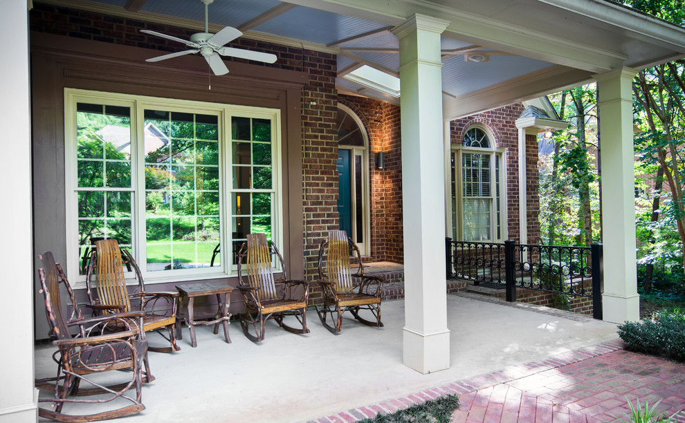 Photo of a mid-sized traditional front yard verandah in Atlanta with brick pavers and a roof extension.