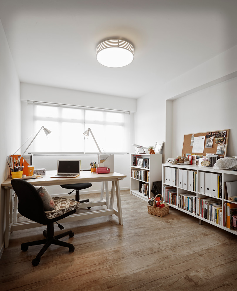 This is an example of a scandinavian study room in Singapore with white walls and a freestanding desk.
