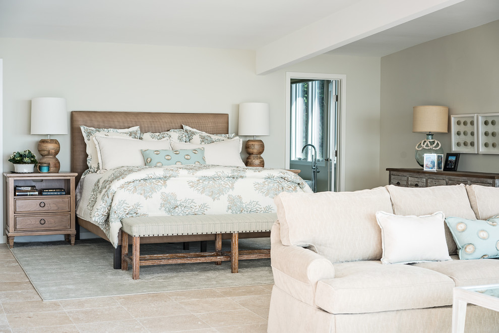 Inspiration for a large beach style master bedroom in Orange County with grey walls, travertine floors, no fireplace and grey floor.