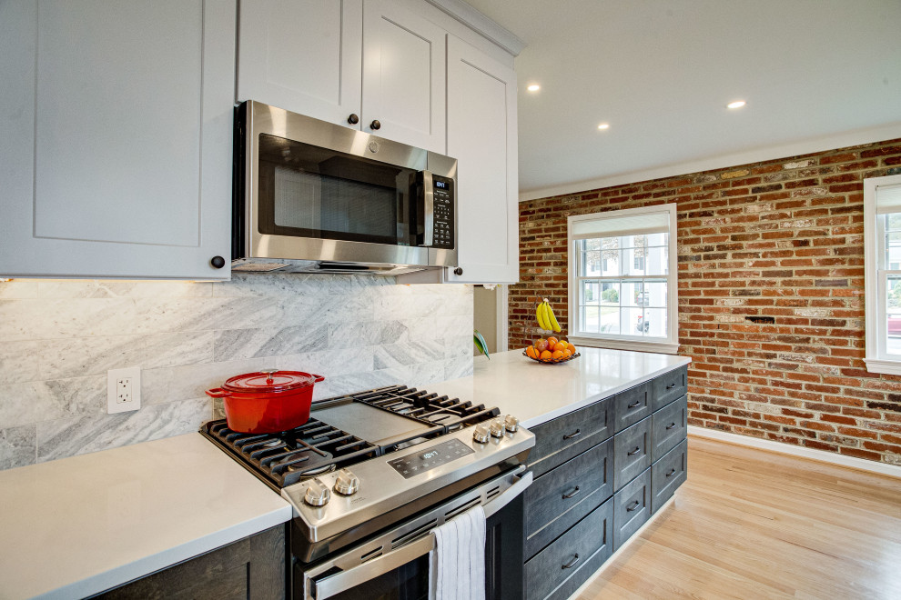 Example of a small transitional single-wall kitchen design in DC Metro with a farmhouse sink, quartz countertops, stainless steel appliances and a peninsula