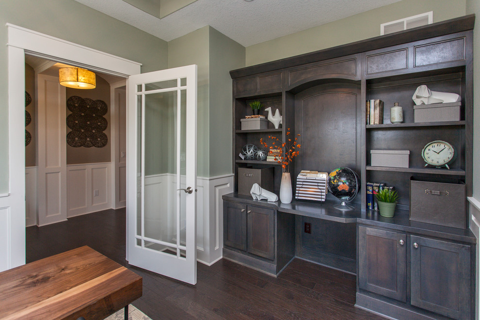 Transitional study room in Other with green walls and dark hardwood floors.