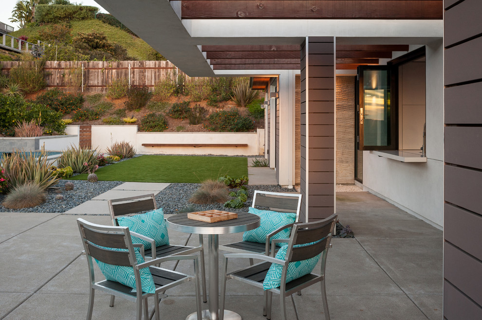 Photo of a mid-sized contemporary backyard patio in San Diego with concrete slab and a roof extension.