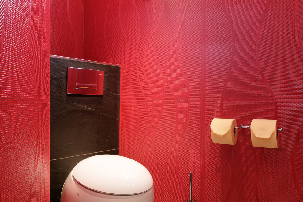 Cette image montre un très grand WC suspendu asiatique avec un carrelage rouge, un carrelage en pâte de verre, un mur noir, un sol en ardoise, un plan vasque, un plan de toilette en verre, un sol noir, meuble-lavabo sur pied et un plafond décaissé.
