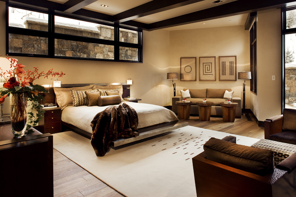 Photo of a contemporary bedroom in Denver with beige walls and light hardwood floors.