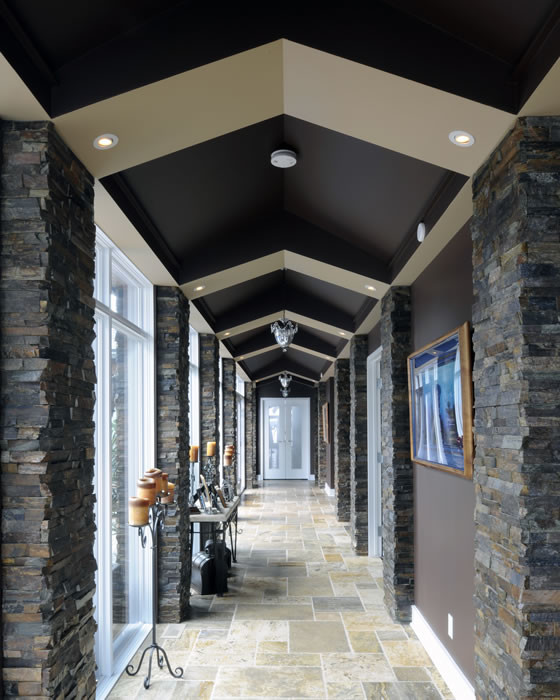 Mid-sized transitional hallway in Ottawa with brown walls, limestone floors and multi-coloured floor.