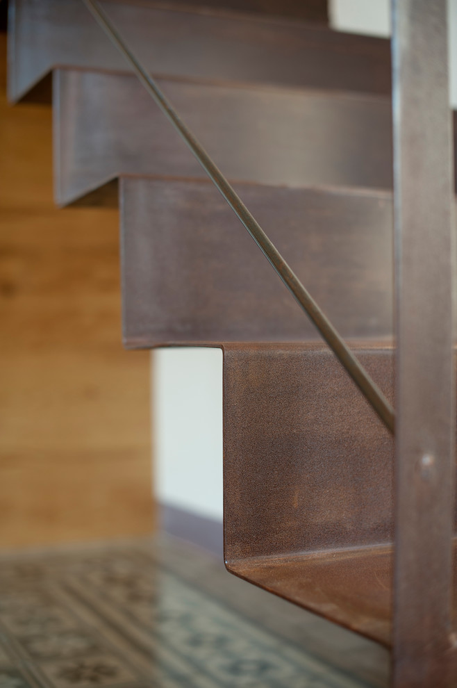 Ejemplo de escalera suspendida con escalones de metal y contrahuellas de metal