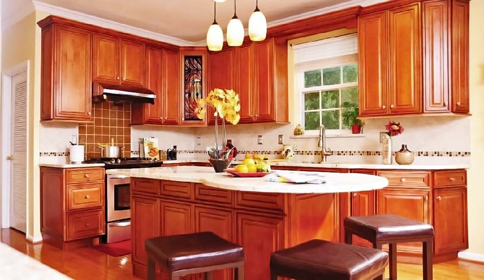 Enclosed kitchen - mid-sized transitional l-shaped medium tone wood floor enclosed kitchen idea with an undermount sink, raised-panel cabinets, medium tone wood cabinets, granite countertops, beige backsplash, mosaic tile backsplash, stainless steel appliances and an island
