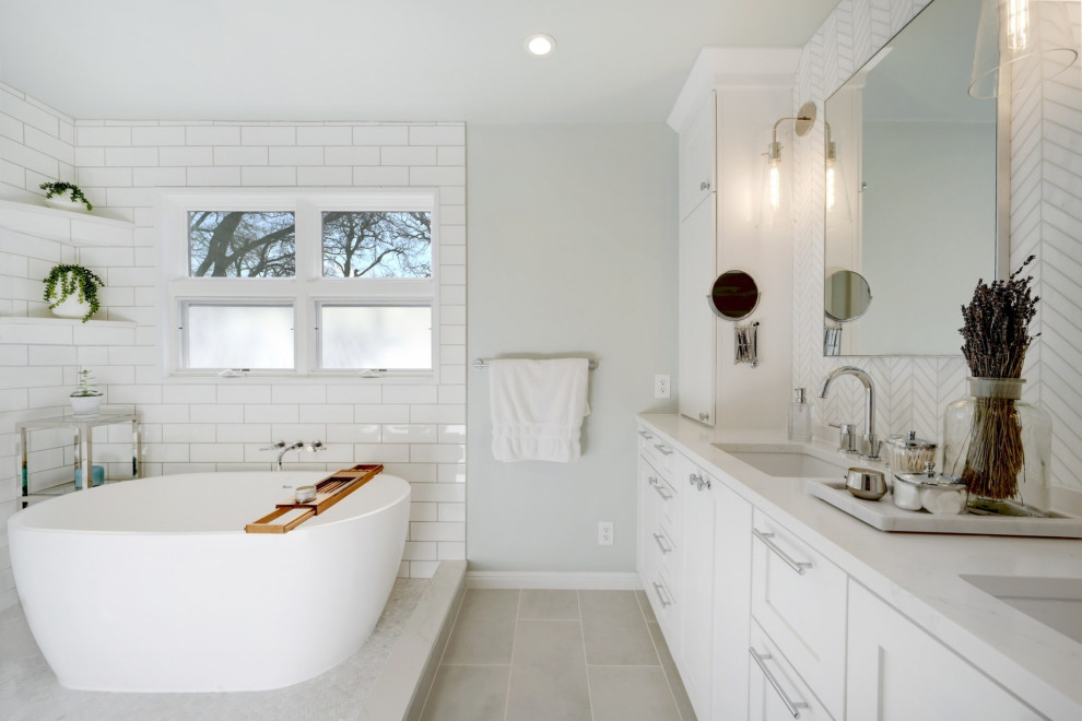 Photo of a transitional master wet room bathroom in Austin with recessed-panel cabinets, white cabinets, a freestanding tub, white tile, grey walls, an undermount sink, grey floor, an open shower, white benchtops, a double vanity and a built-in vanity.