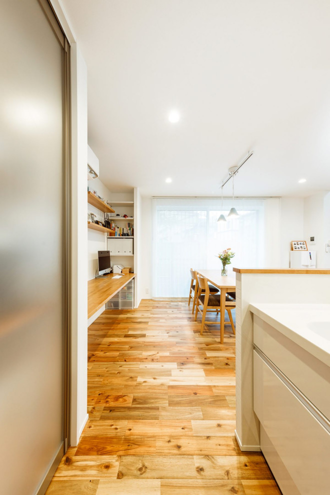 Inspiration för ett mellanstort industriellt vit linjärt vitt kök med öppen planlösning, med en undermonterad diskho, luckor med profilerade fronter, vita skåp, bänkskiva i koppar, mellanmörkt trägolv, en köksö och brunt golv