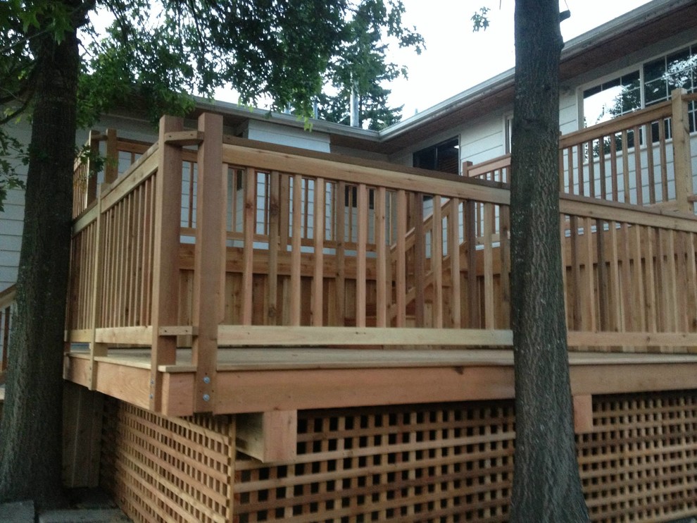 Example of a large backyard deck design in Vancouver with a pergola