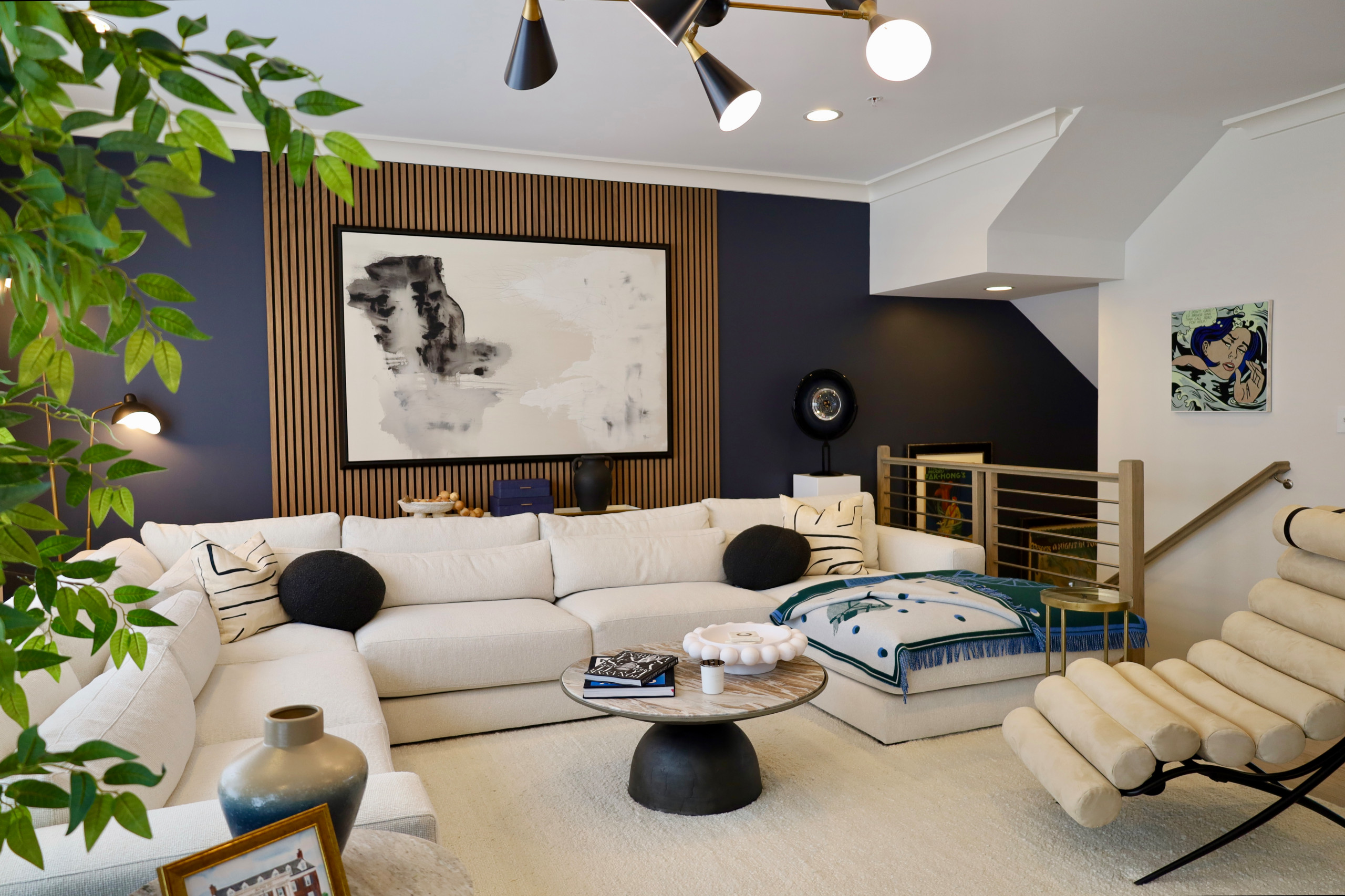 This modern luxury living room design blends clean lines, rich contrast, and layered textures to create a sophisticated yet inviting space. A custom wood slat accent wall adds architectural interest a