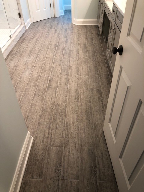 Mid-sized transitional master white tile and porcelain tile porcelain tile and gray floor alcove shower photo with recessed-panel cabinets, gray cabinets, a two-piece toilet, an undermount sink, quartzite countertops, a hinged shower door and white countertops