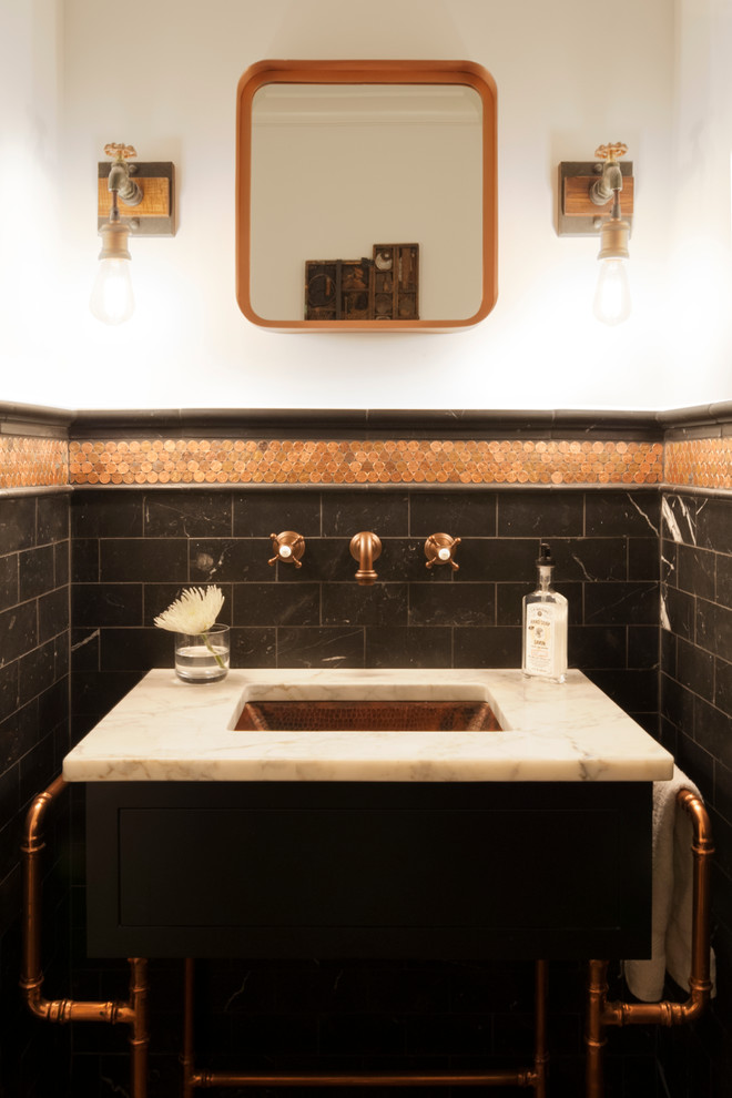 This is an example of a small industrial powder room in Cleveland with flat-panel cabinets, black cabinets, black tile, subway tile, white walls, an undermount sink and marble benchtops.