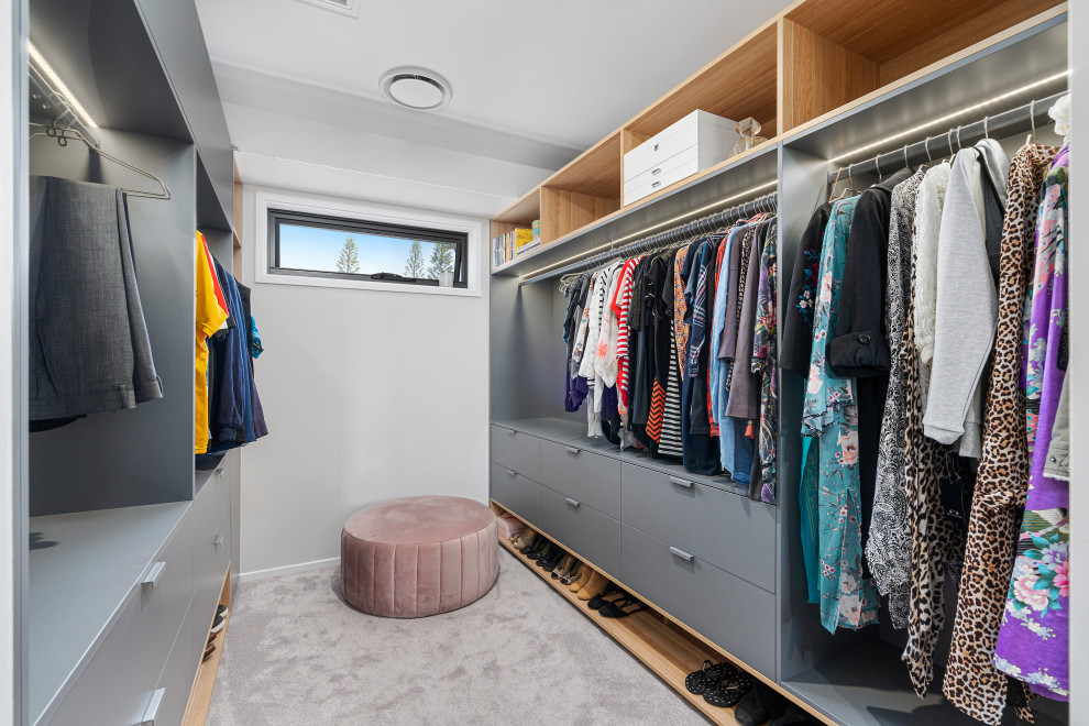 Inspiration for a small contemporary gender-neutral walk-in wardrobe in Gold Coast - Tweed with flat-panel cabinets, grey cabinets, carpet and grey floor.