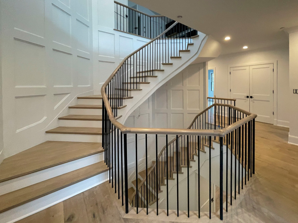 Inspiration for a large transitional wood floating staircase in DC Metro with painted wood risers, mixed railing and decorative wall panelling.