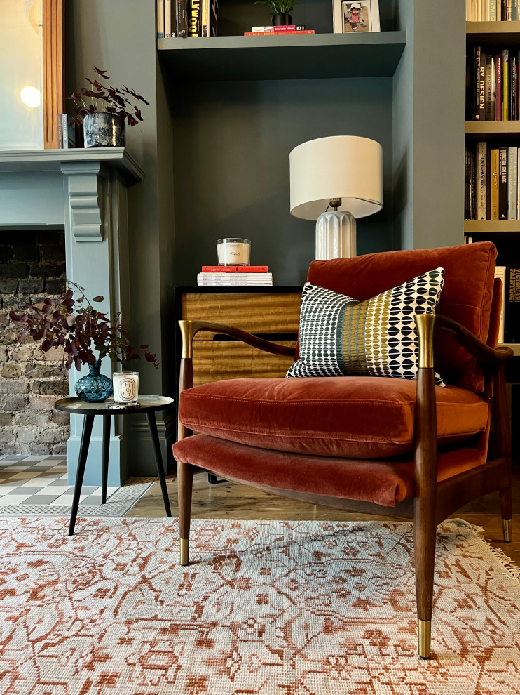 Mittelgroßes Eklektisches Wohnzimmer mit blauer Wandfarbe, Kamin, Kaminumrandung aus Holz, freistehendem TV und braunem Boden in London