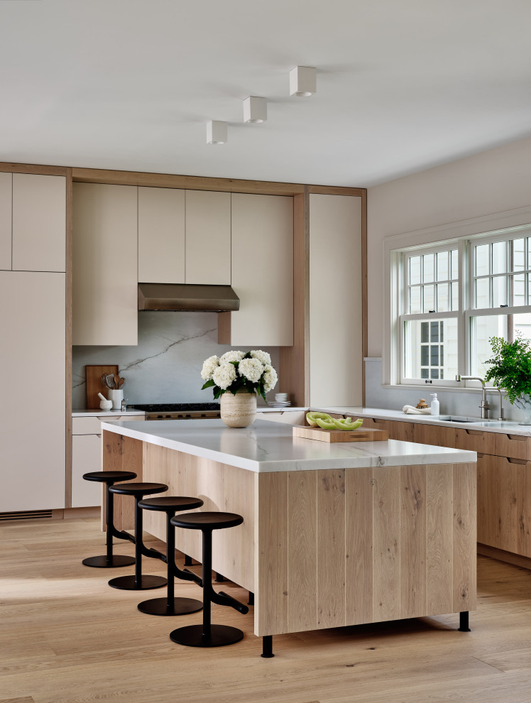 Inspiration for a contemporary u-shaped open plan kitchen in New York with a submerged sink, flat-panel cabinets, white cabinets, marble worktops, multi-coloured splashback, marble splashback, integrated appliances, medium hardwood flooring, an island, brown floors and multicoloured worktops.