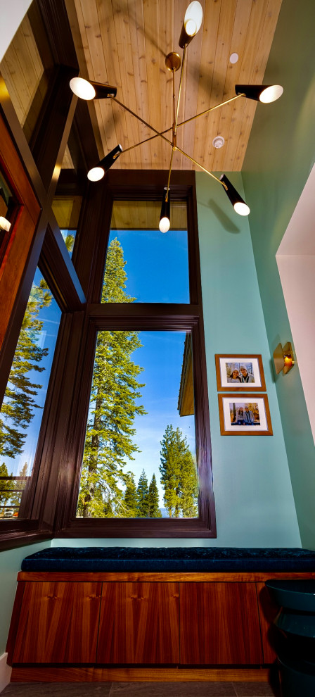 Mittelgroßes Mid-Century Foyer mit blauer Wandfarbe, braunem Holzboden, Drehtür, Haustür aus Metall, beigem Boden und Holzdielendecke in Sacramento