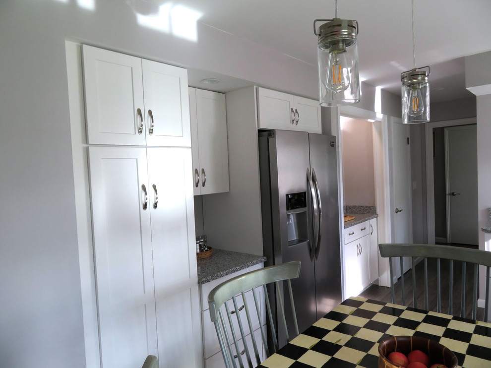 Eat-in kitchen - large transitional l-shaped dark wood floor and brown floor eat-in kitchen idea with an undermount sink, recessed-panel cabinets, white cabinets, granite countertops, stainless steel appliances, no island and gray countertops