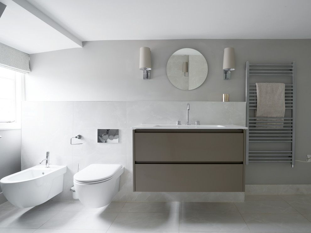 Photo of a medium sized contemporary family bathroom in Other with flat-panel cabinets, grey cabinets, grey tiles, ceramic tiles, ceramic flooring, grey floors, a single sink, a floating vanity unit, a wall mounted toilet, grey walls, an integrated sink and white worktops.