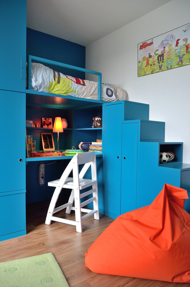 Design ideas for a mid-sized contemporary gender-neutral kids' bedroom for kids 4-10 years old in Paris with white walls and light hardwood floors.