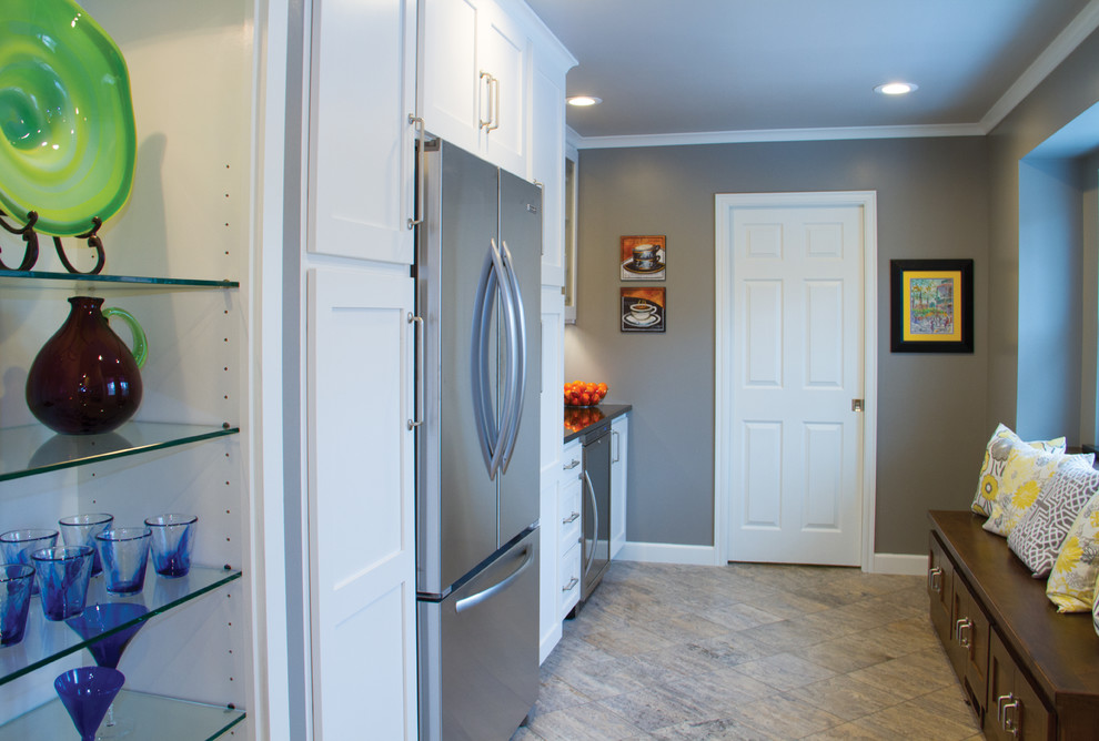 Inspiration for a transitional porcelain tile eat-in kitchen remodel with shaker cabinets, white cabinets, granite countertops, white backsplash, subway tile backsplash and stainless steel appliances