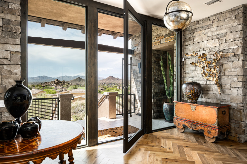 This is an example of an expansive entrance in Phoenix with brown walls, medium hardwood flooring, a single front door, a glass front door and beige floors.