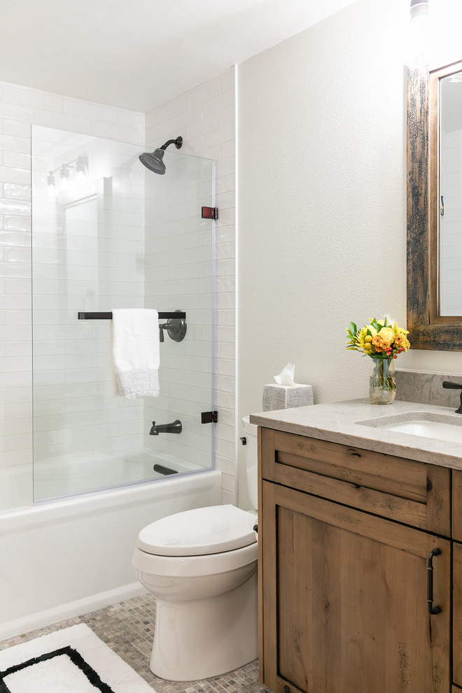 Mid-sized contemporary master bathroom in Denver with shaker cabinets, medium wood cabinets, a corner tub, a shower/bathtub combo, a one-piece toilet, white tile, ceramic tile, white walls, mosaic tile floors, an undermount sink, marble benchtops, a hinged shower door and beige benchtops.