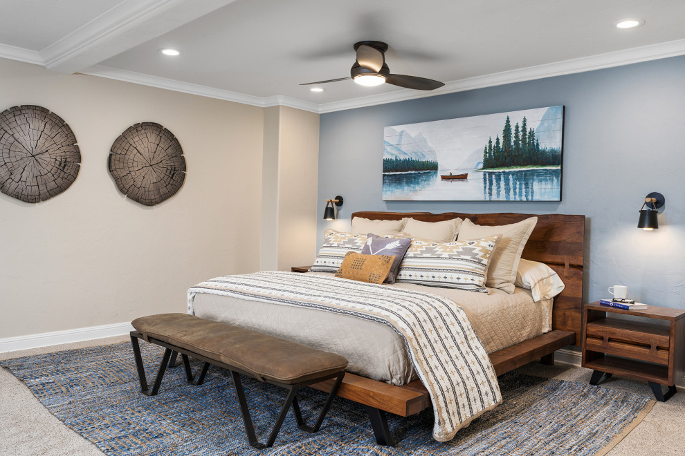 Großes Rustikales Hauptschlafzimmer mit blauer Wandfarbe, Teppichboden, Eckkamin, Kaminumrandung aus Stein, grauem Boden und Holzwänden in Sonstige
