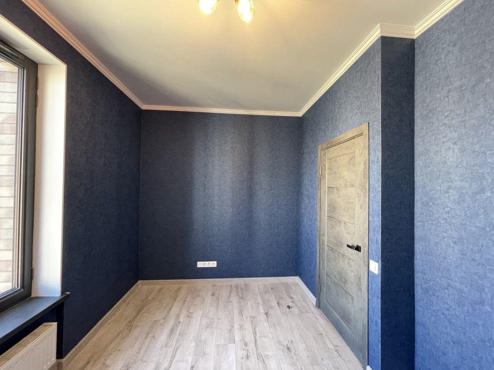 Imagen de dormitorio principal actual de tamaño medio con paredes azules, suelo laminado, suelo beige y papel pintado