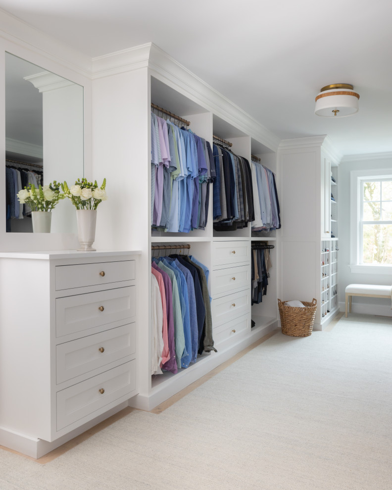 Inspiration for a large transitional gender-neutral walk-in closet remodel in New York with white cabinets