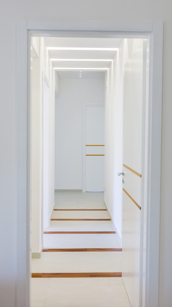 Idee per un piccolo ingresso o corridoio contemporaneo con pareti bianche, pavimento in gres porcellanato, pavimento bianco e soffitto a cassettoni
