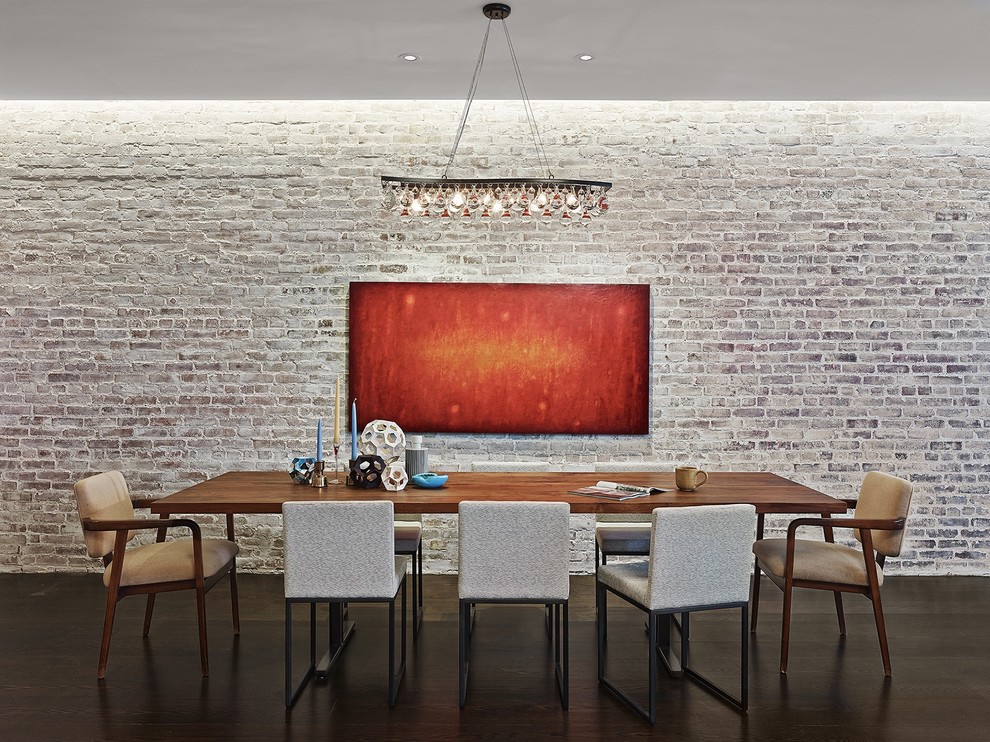 Photo of an industrial dining room in New York with dark hardwood floors.