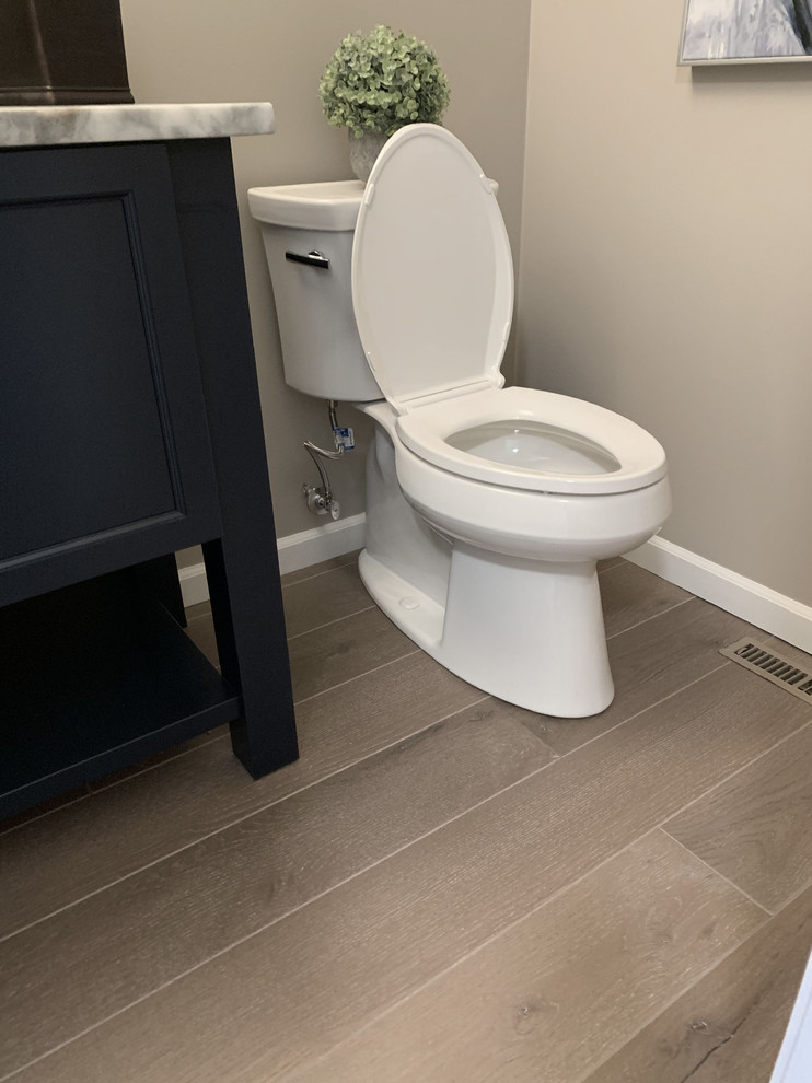 This is an example of a mid-sized transitional 3/4 bathroom in Other with shaker cabinets, blue cabinets, a two-piece toilet, grey walls, granite benchtops and multi-coloured benchtops.