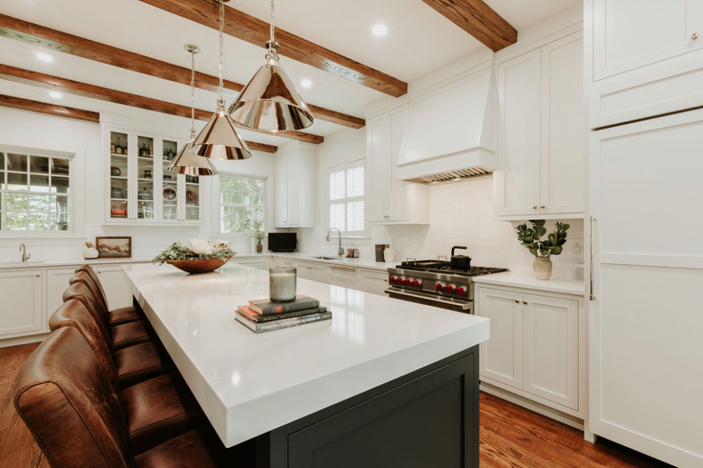 Example of a large transitional u-shaped medium tone wood floor, brown floor and exposed beam eat-in kitchen design with a single-bowl sink, recessed-panel cabinets, white cabinets, quartz countertops, white backsplash, marble backsplash, stainless steel appliances, an island and white countertops