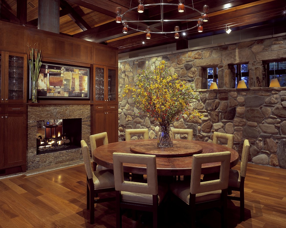This is an example of a country dining room in Charleston with a two-sided fireplace.