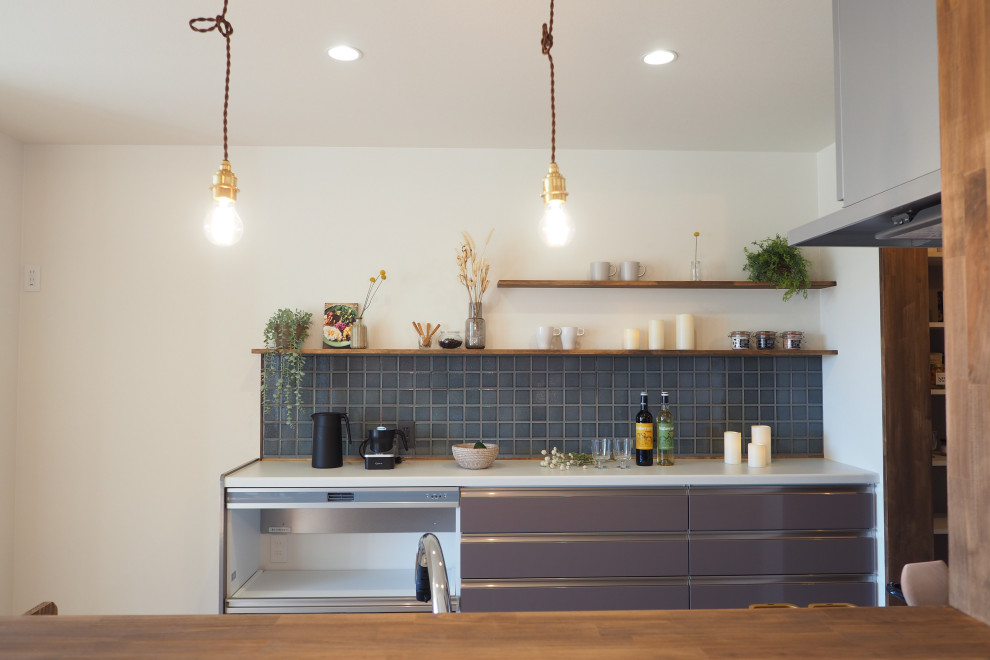 Réalisation d'une cuisine ouverte urbaine avec des portes de placard marrons, une crédence marron, un électroménager en acier inoxydable, un sol en vinyl, un sol beige et un plafond en papier peint.