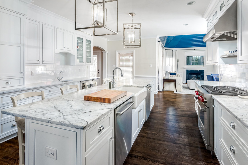 Kitchen - transitional dark wood floor kitchen idea in Richmond with a farmhouse sink, shaker cabinets, white cabinets, marble countertops, white backsplash, subway tile backsplash, stainless steel appliances and an island