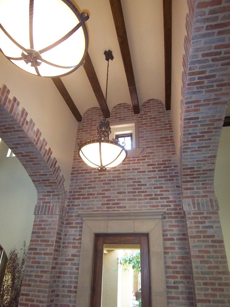 Large tuscan ceramic tile front door photo with a medium wood front door