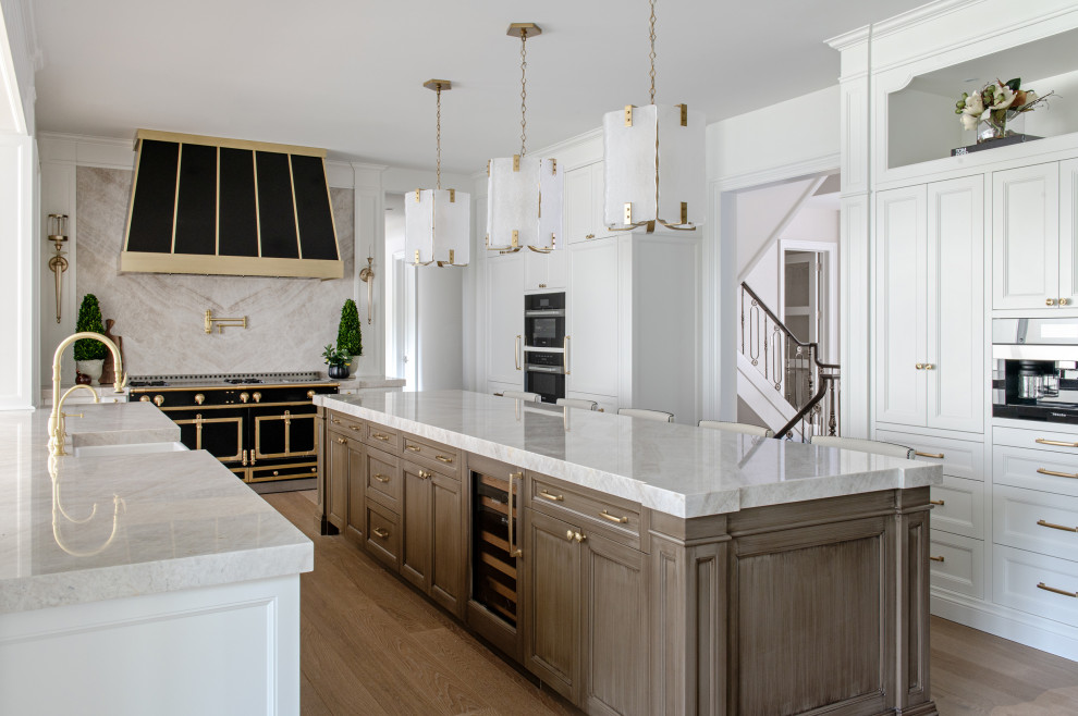 Eat-in kitchen - large transitional u-shaped light wood floor eat-in kitchen idea in Toronto with a farmhouse sink, beaded inset cabinets, yellow cabinets, multicolored backsplash, black appliances, an island and multicolored countertops